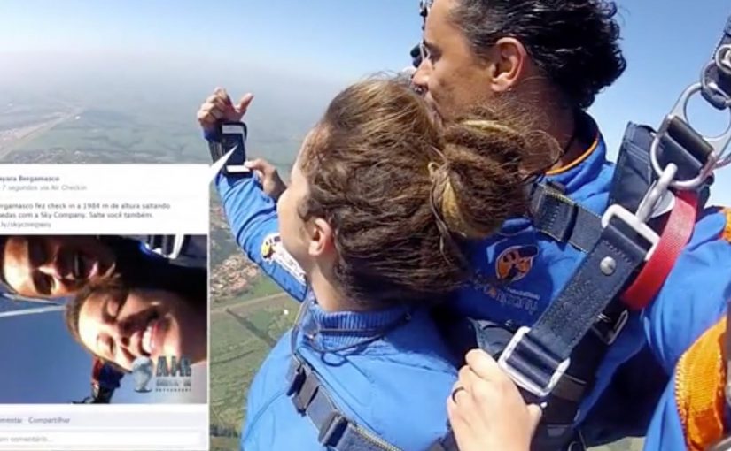Skydiver in free fall uses a smartphone to post an Air Check-in update.