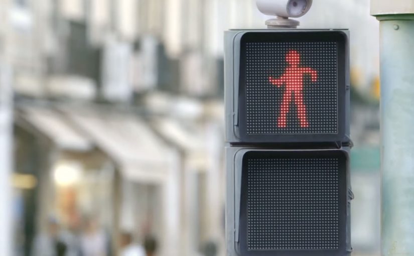 A pedestrian traffic light shows a red figure dancing in real time.
