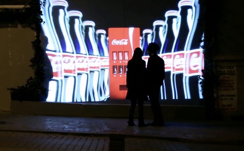 An “invisible” Coca-Cola vending machine reveals itself on a street wall when a couple stands in front of it.