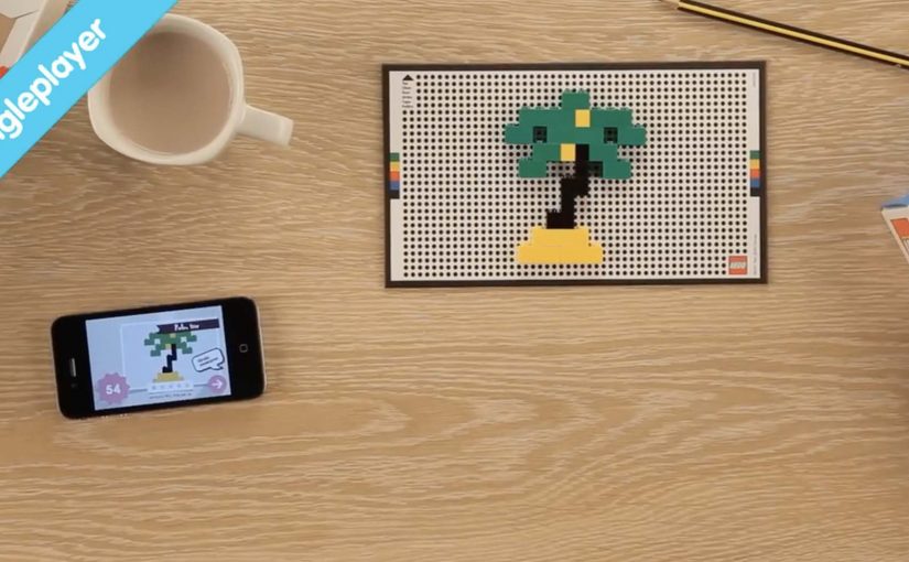 A child rebuilds a travel picture with LEGO bricks on a dotted playmat for the Life of George app.