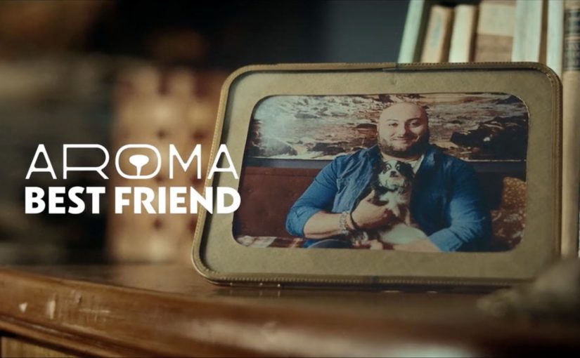 Framed photo of a man holding a small dog on a shelf beside the words Aroma Best Friend.