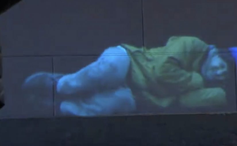 Street projection invites passers-by to text, change the scene, then see a donation prompt.